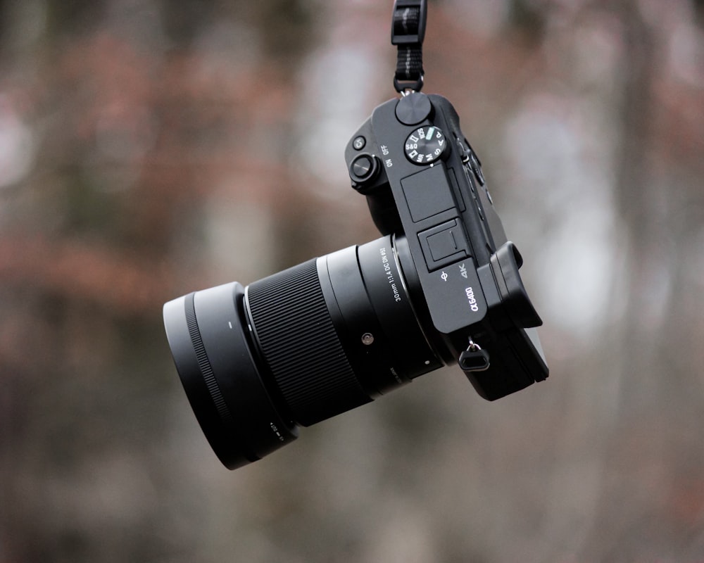 black dslr camera on brown wooden table