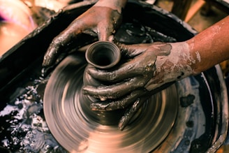 person making clay pot with water