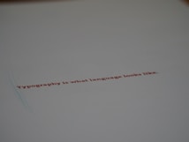 A minimalistic design featuring a piece of paper with the text 'Typography is what language looks like.' written in red ink. The focus on the text gives a stylish and modern feel with ample white space around it.
