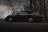 black porsche 911 parked near bare trees during daytime