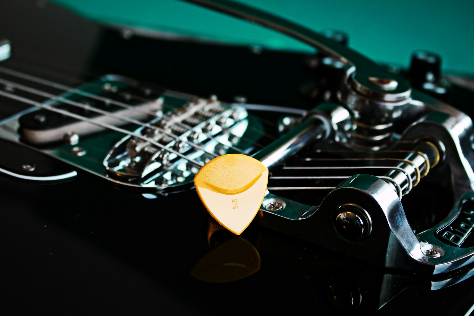 yellow guitar pick on black guitar