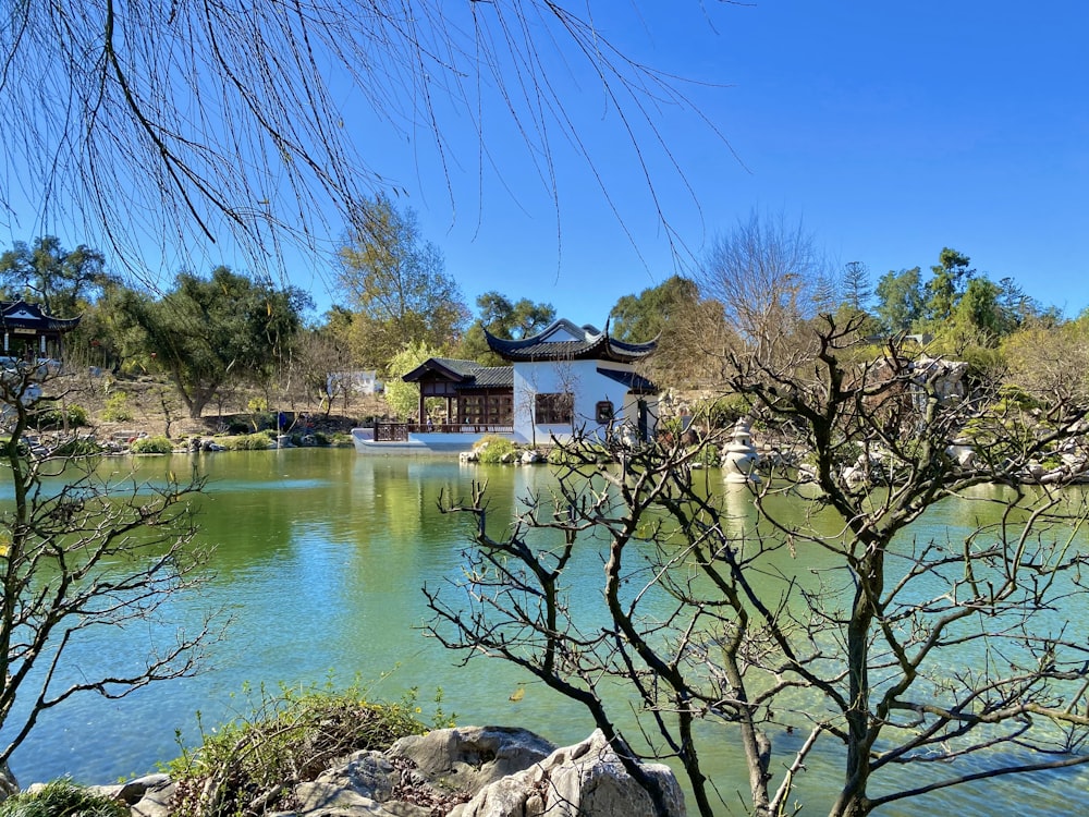 brown and white house near body of water under blue sky during daytime