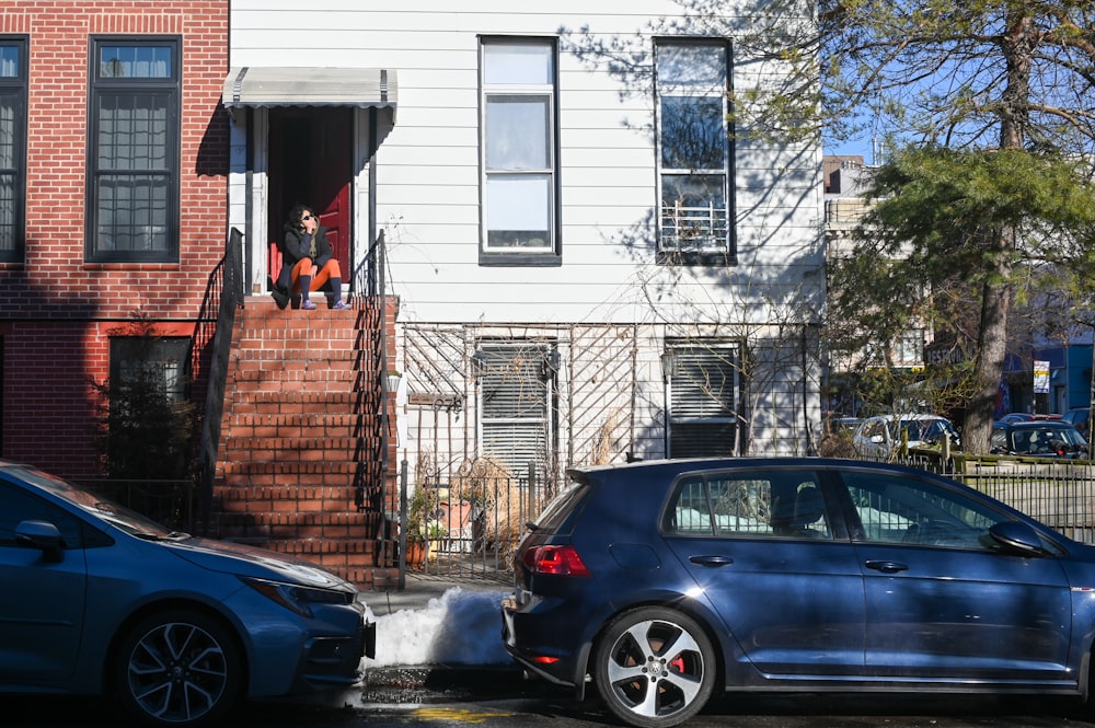 blue car parked beside brown brick building