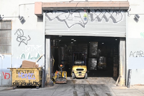 yellow and black auto rickshaw parked beside white and black store