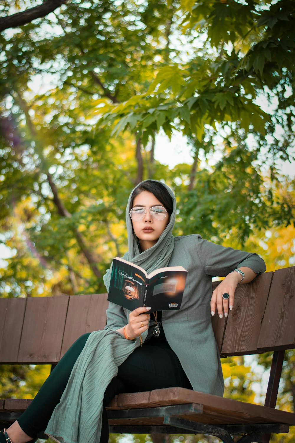 woman in black hoodie sitting on brown wooden bench
