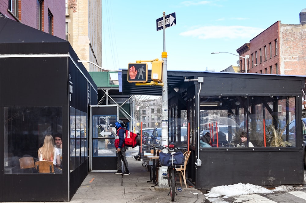 people walking on sidewalk near black and red train during daytime