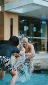 A parent interacting with a child during water play.
