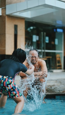 A parent interacting with a child during water play.