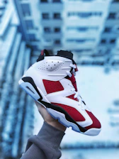 person wearing white red and black nike basketball shoe