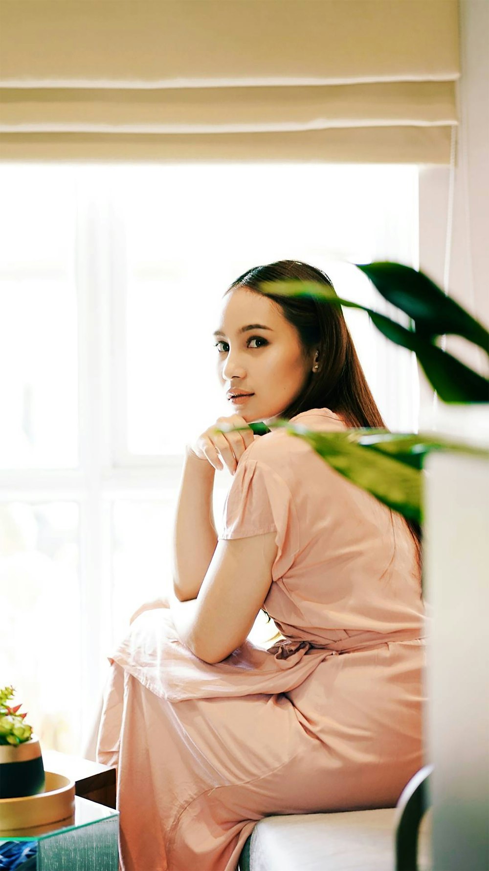 woman in pink dress holding green leaf