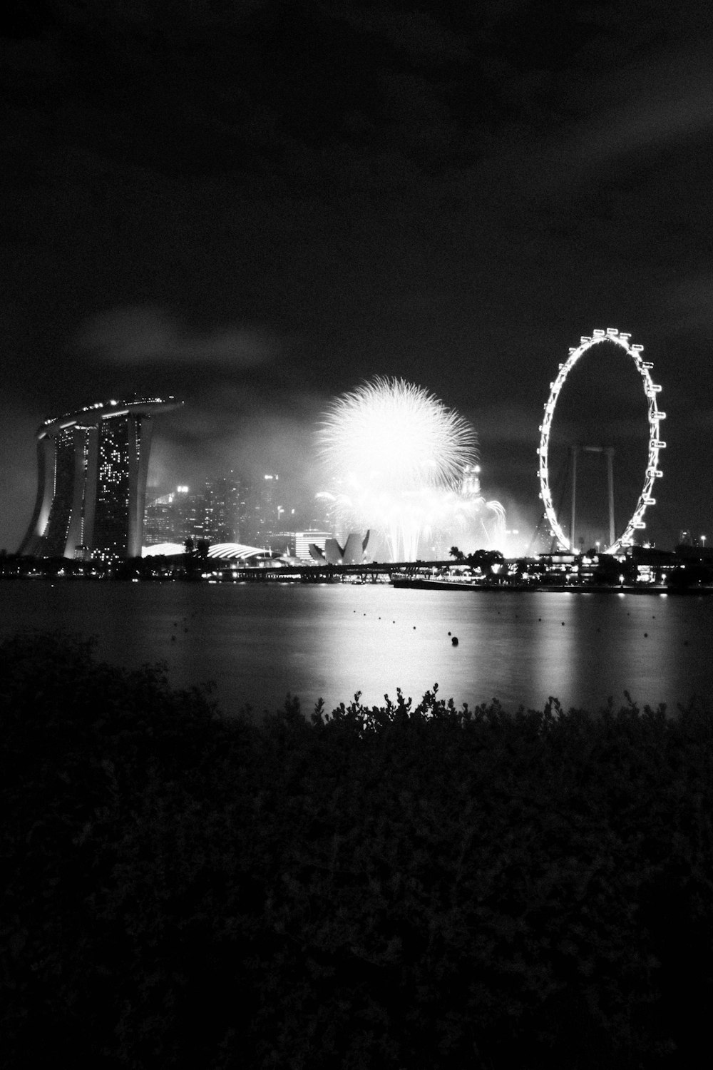 grayscale photo of fireworks display over body of water