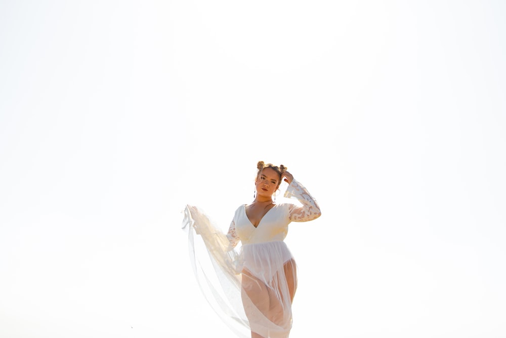 woman in white dress covering her face with her hands