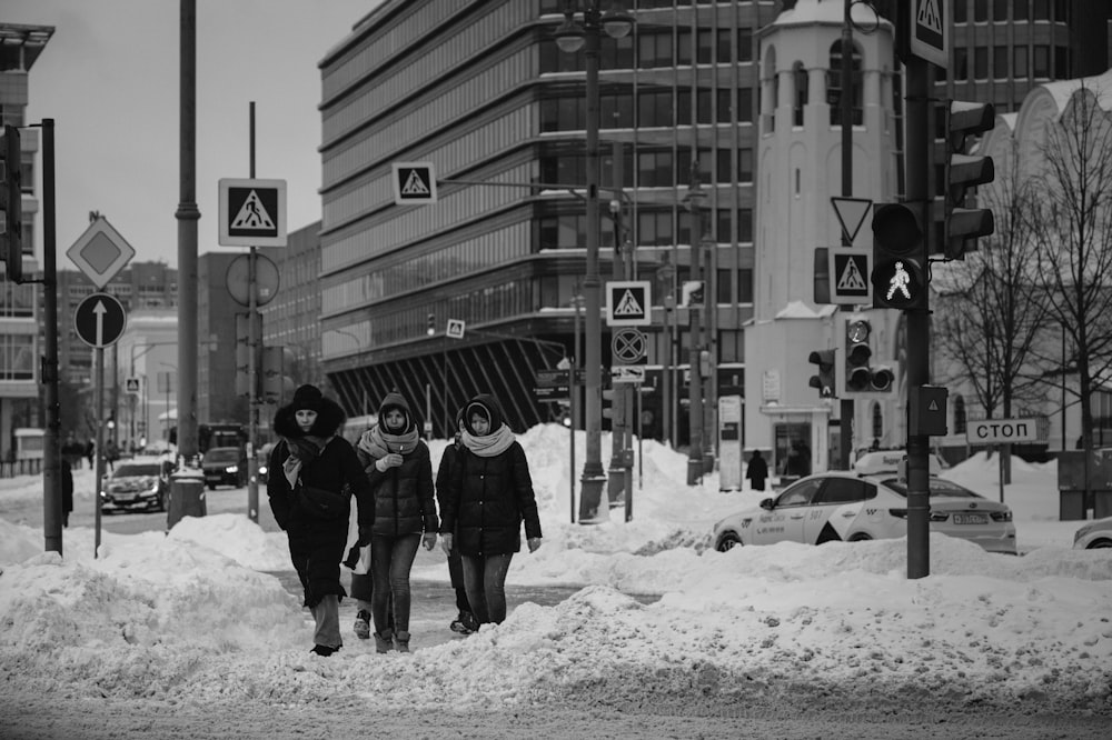 grayscale photo of 2 person walking on snow covered ground