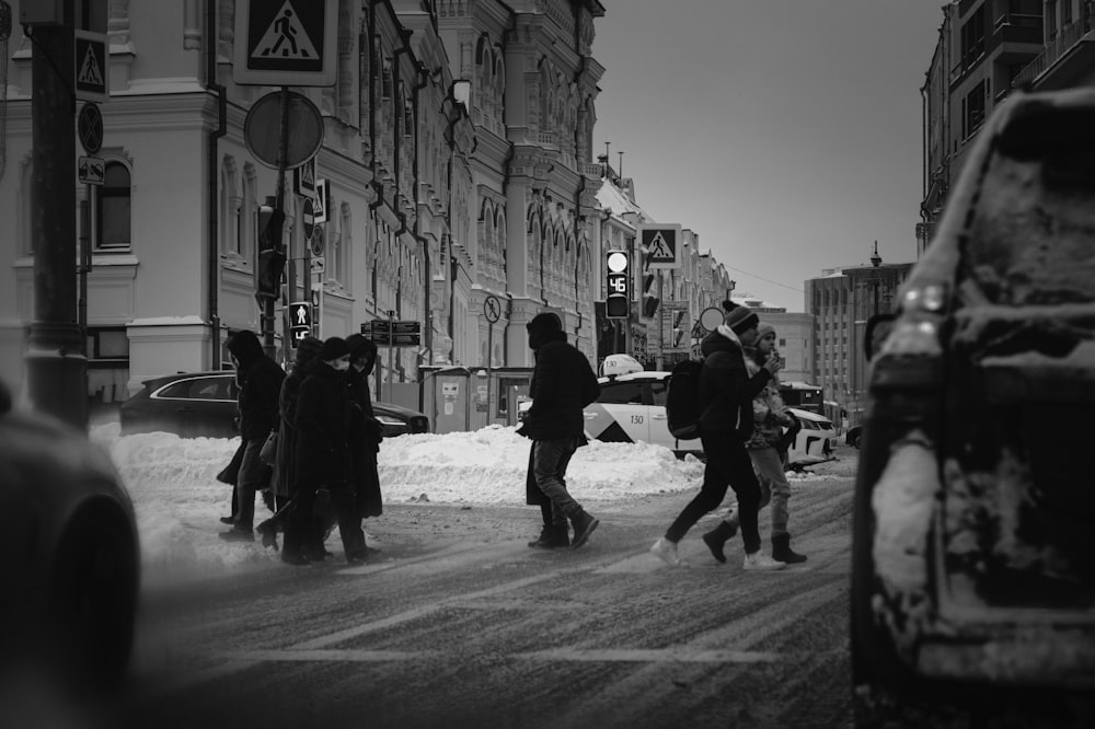 persone che camminano per strada nella fotografia in scala di grigi