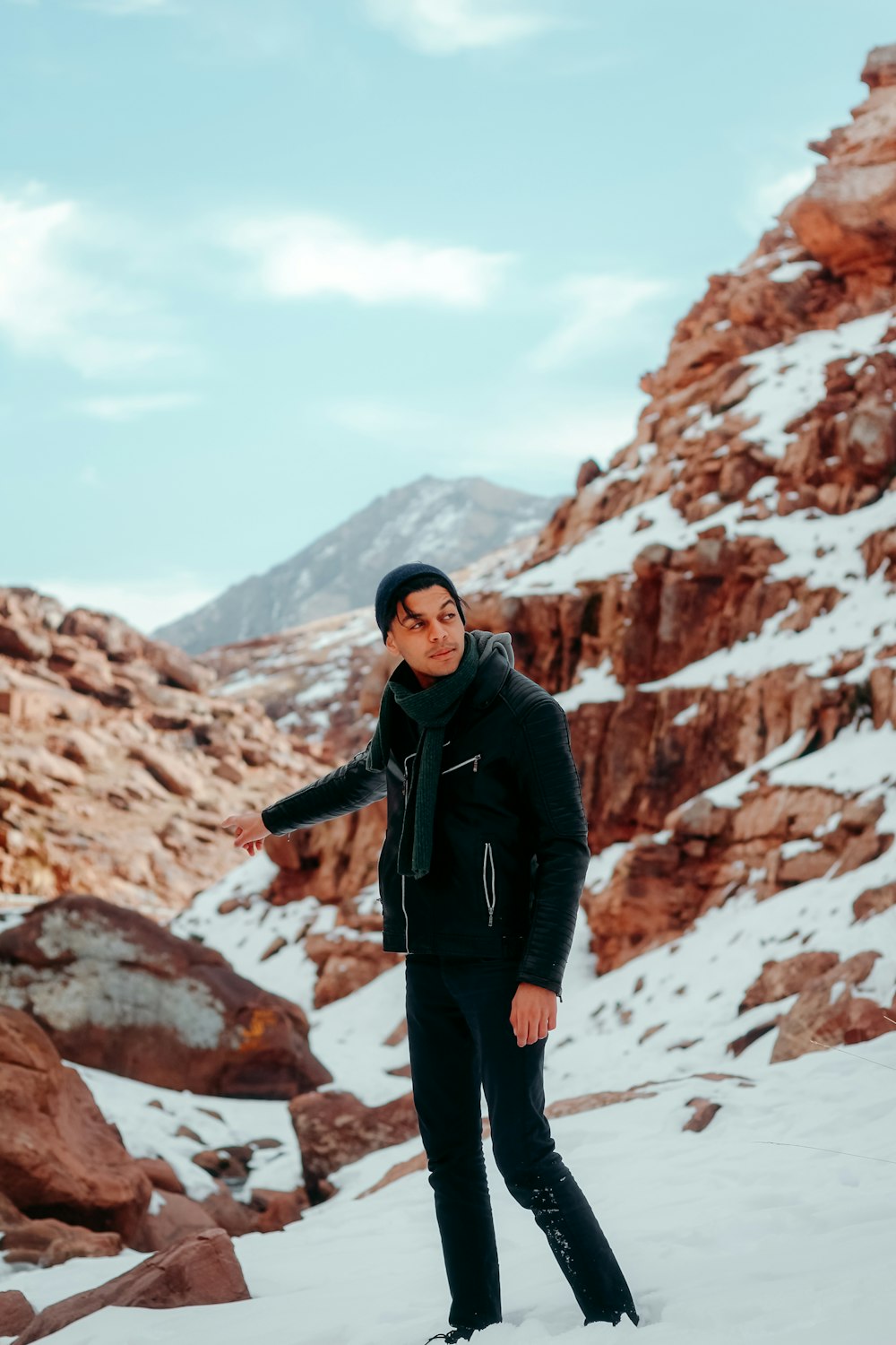 man in black jacket standing on rocky mountain during daytime