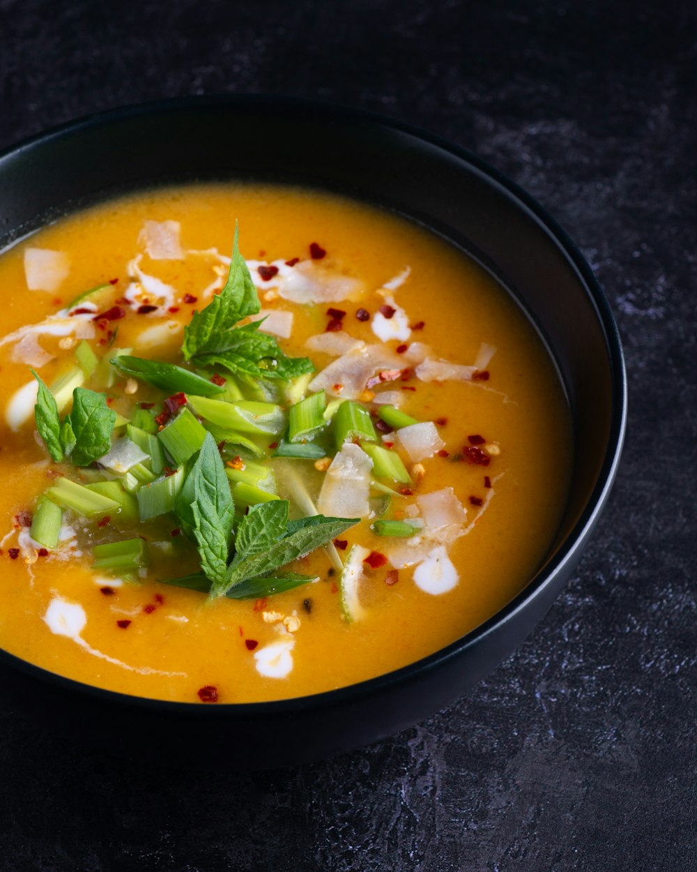 sopa com folha verde na tigela de cerâmica preta