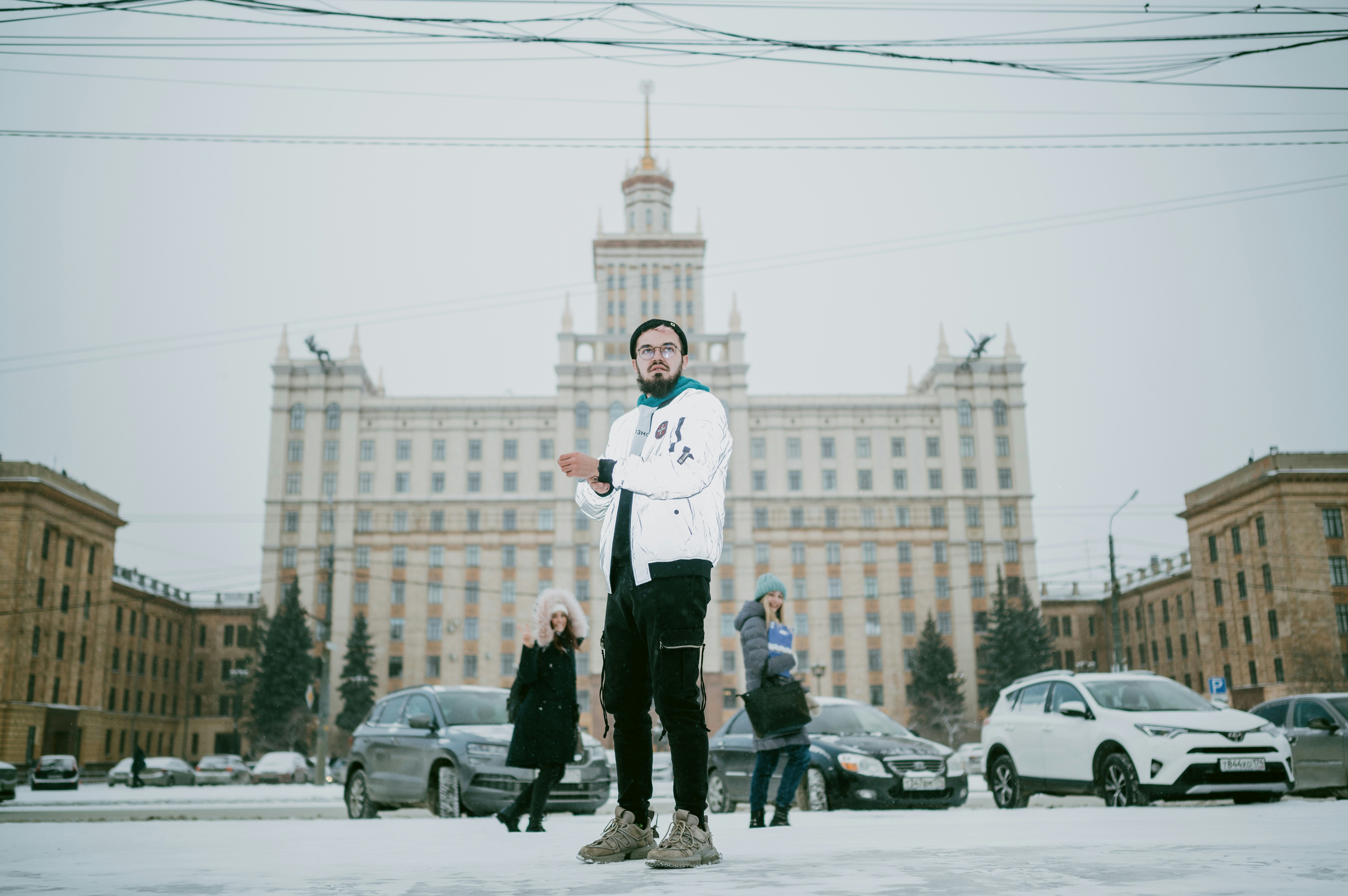 man in white dress shirt and black pants standing on snow covered ground during daytime