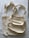 Two beige cloth bags with handles laid flat on a slightly crumpled fabric surface. The bags have a simple, unadorned design and appear to be made of cotton or canvas material.