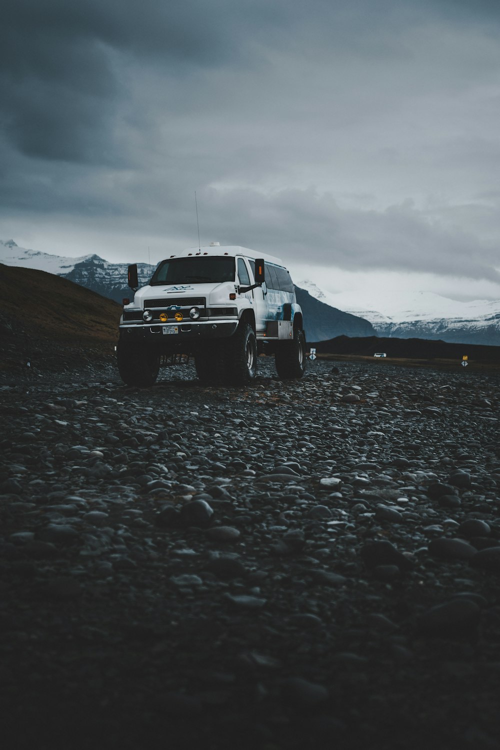 Voiture Chevrolet blanche sur sable gris pendant la journée