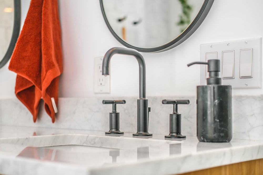 stainless steel faucet on white ceramic sink