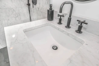 stainless steel faucet on white ceramic sink