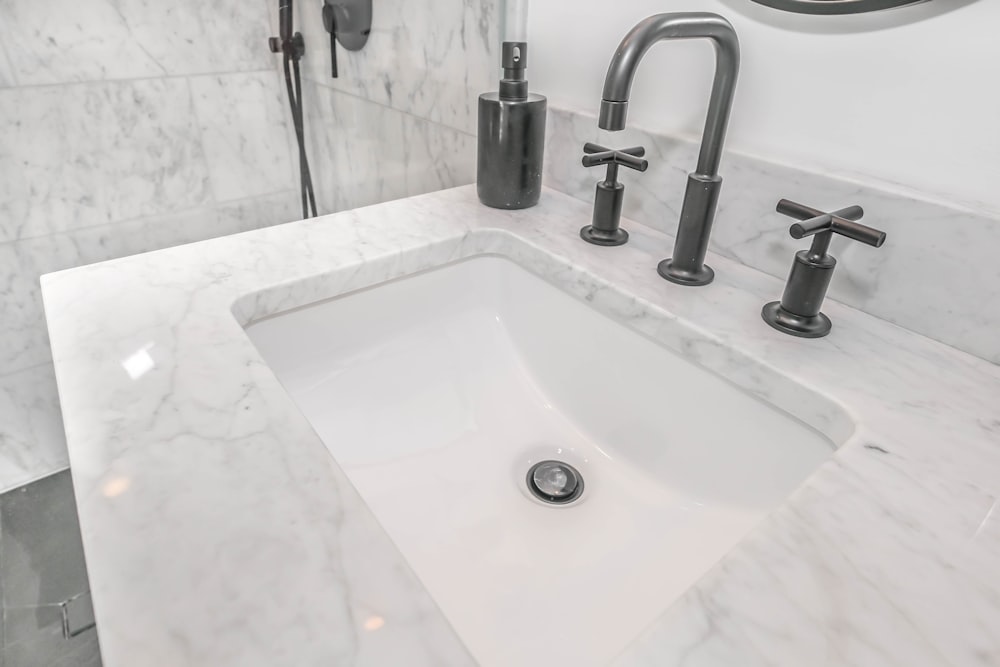 stainless steel faucet on white ceramic sink