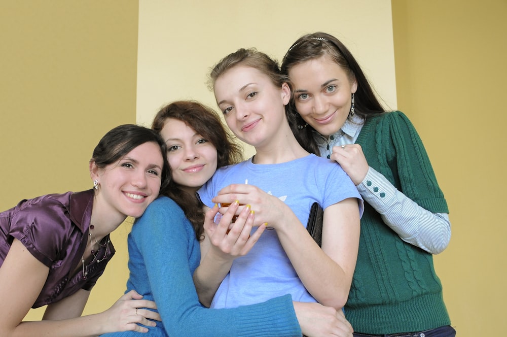 3 women smiling and sitting on green sofa