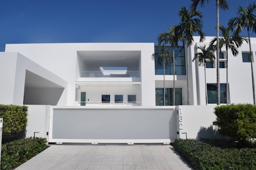 white concrete building with green plants on the side