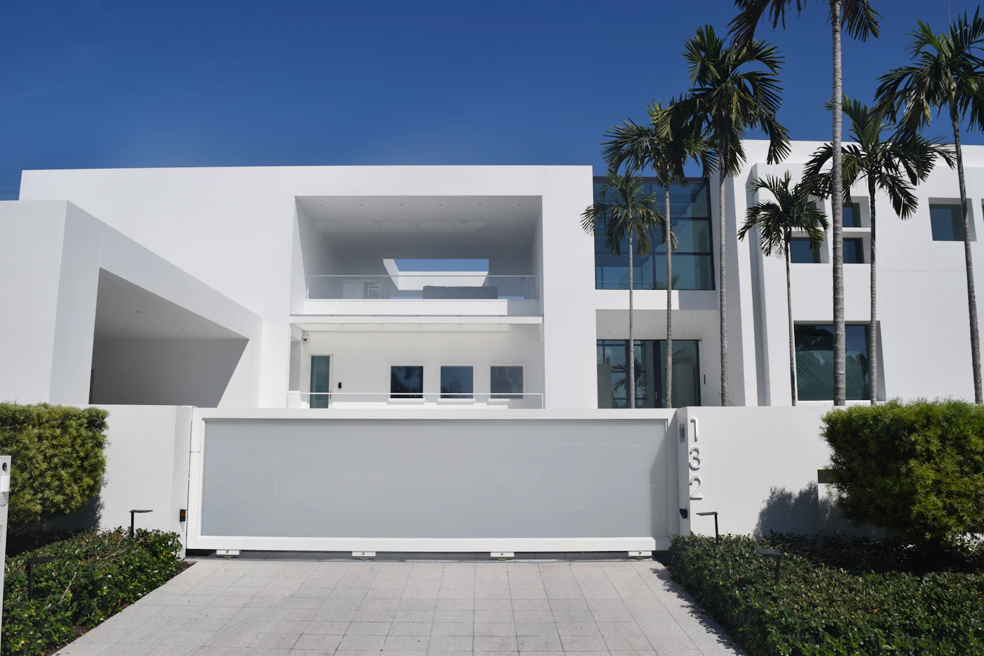 Modern white home behind a closed security gate