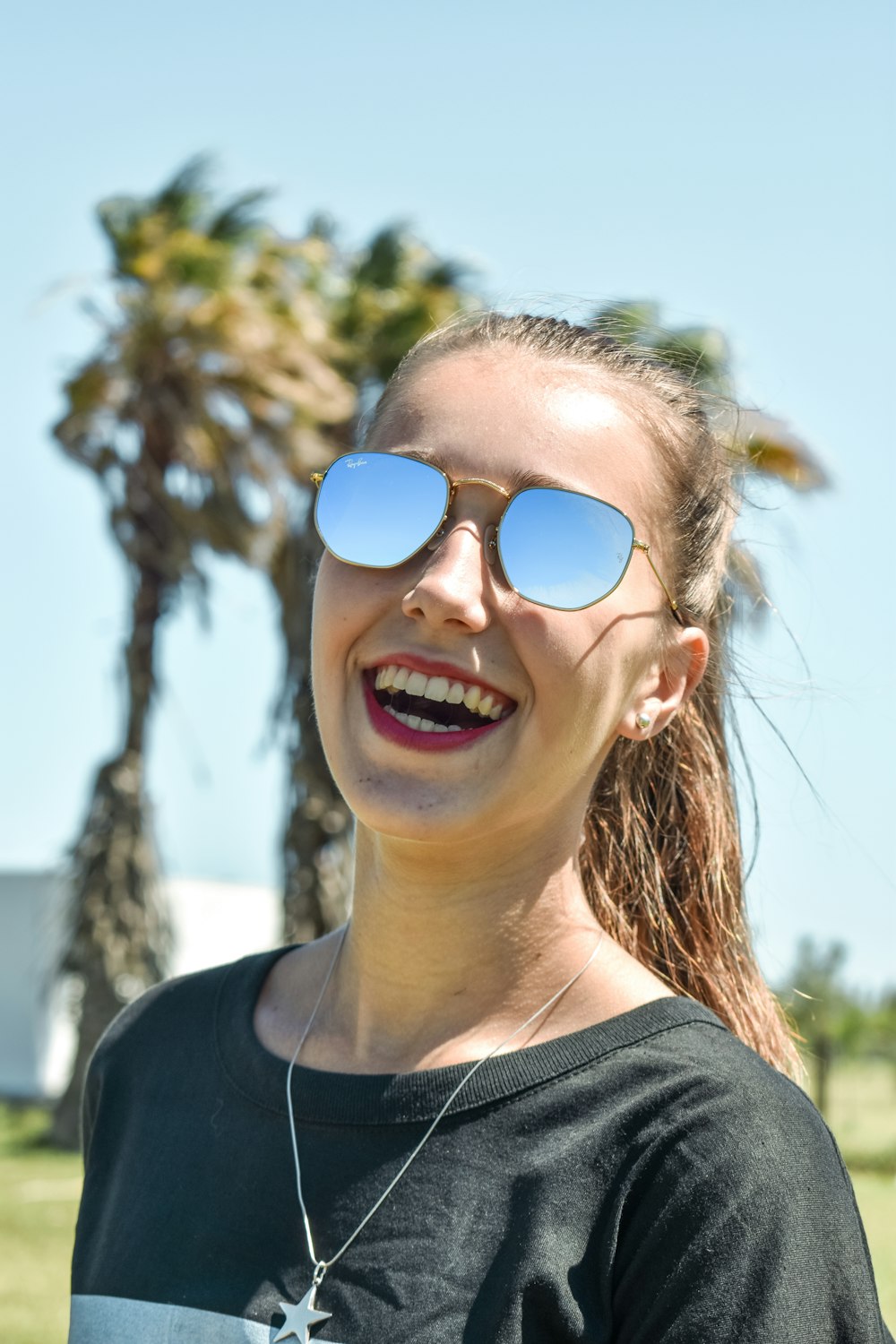 woman in black crew neck shirt wearing blue sunglasses