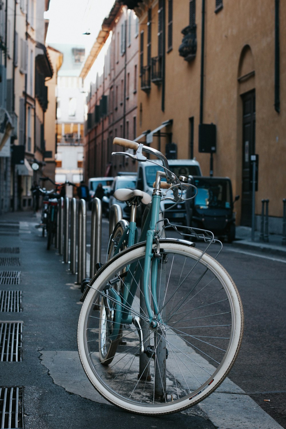 blue city bike parked on black metal fence during daytime