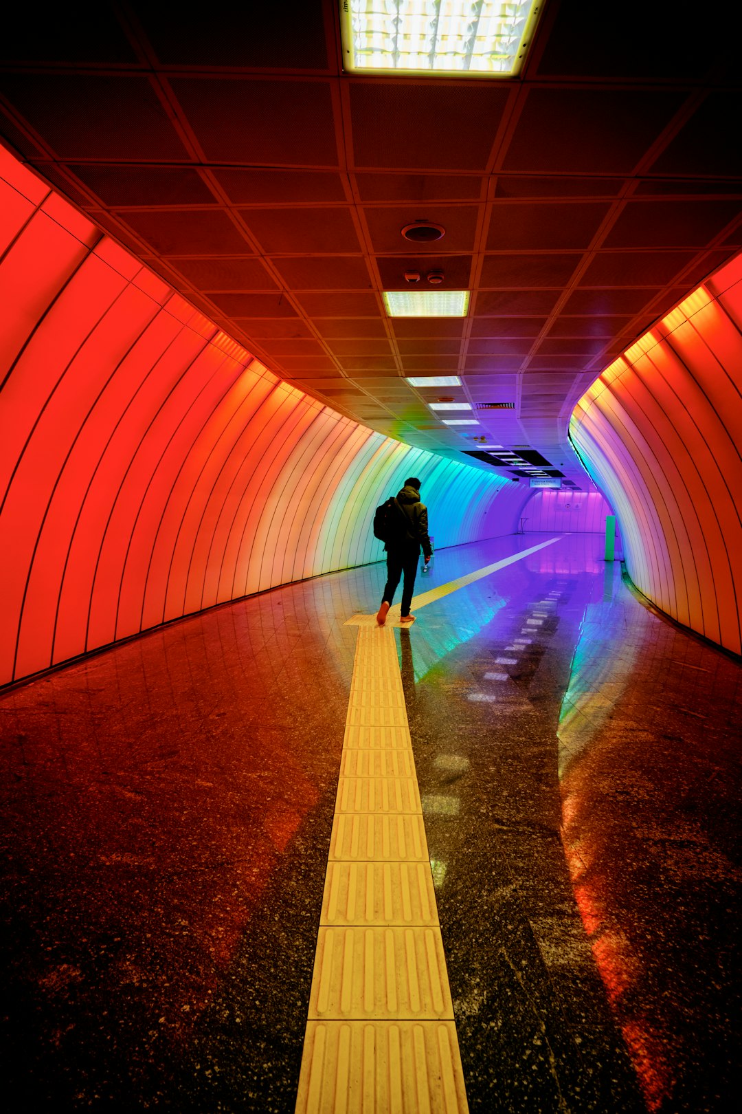 man in black jacket walking on tunnel