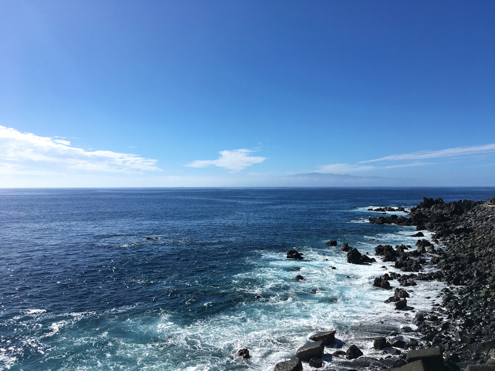 água azul do oceano sob o céu azul durante o dia