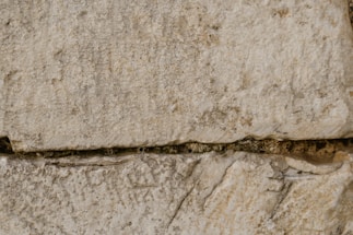 Close-up of skilled mason laying natural stone on a sunny day.