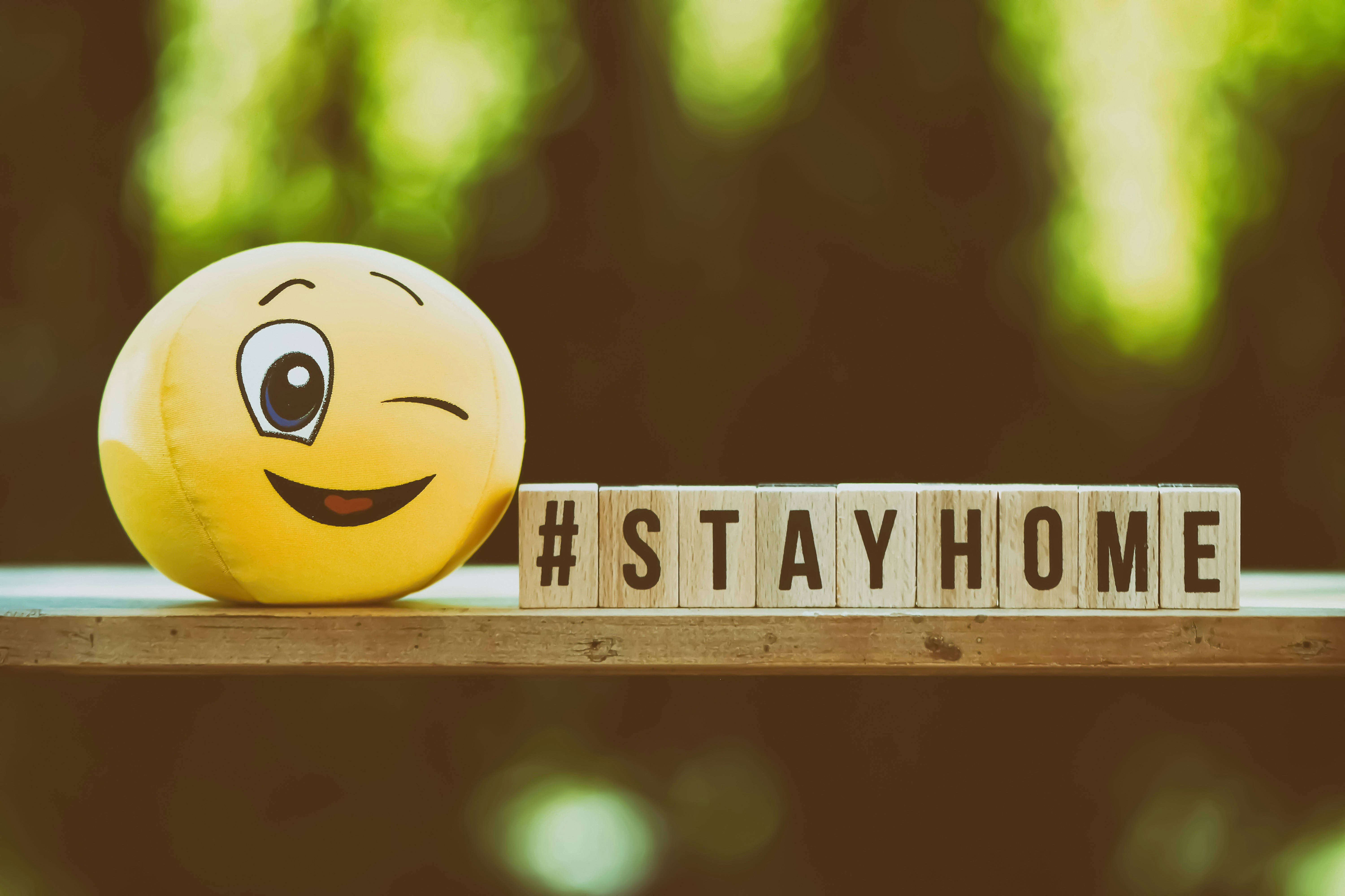 yellow smiley emoji on brown wooden fence