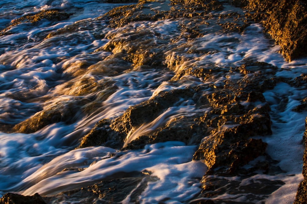 water waves on rocky shore during daytime