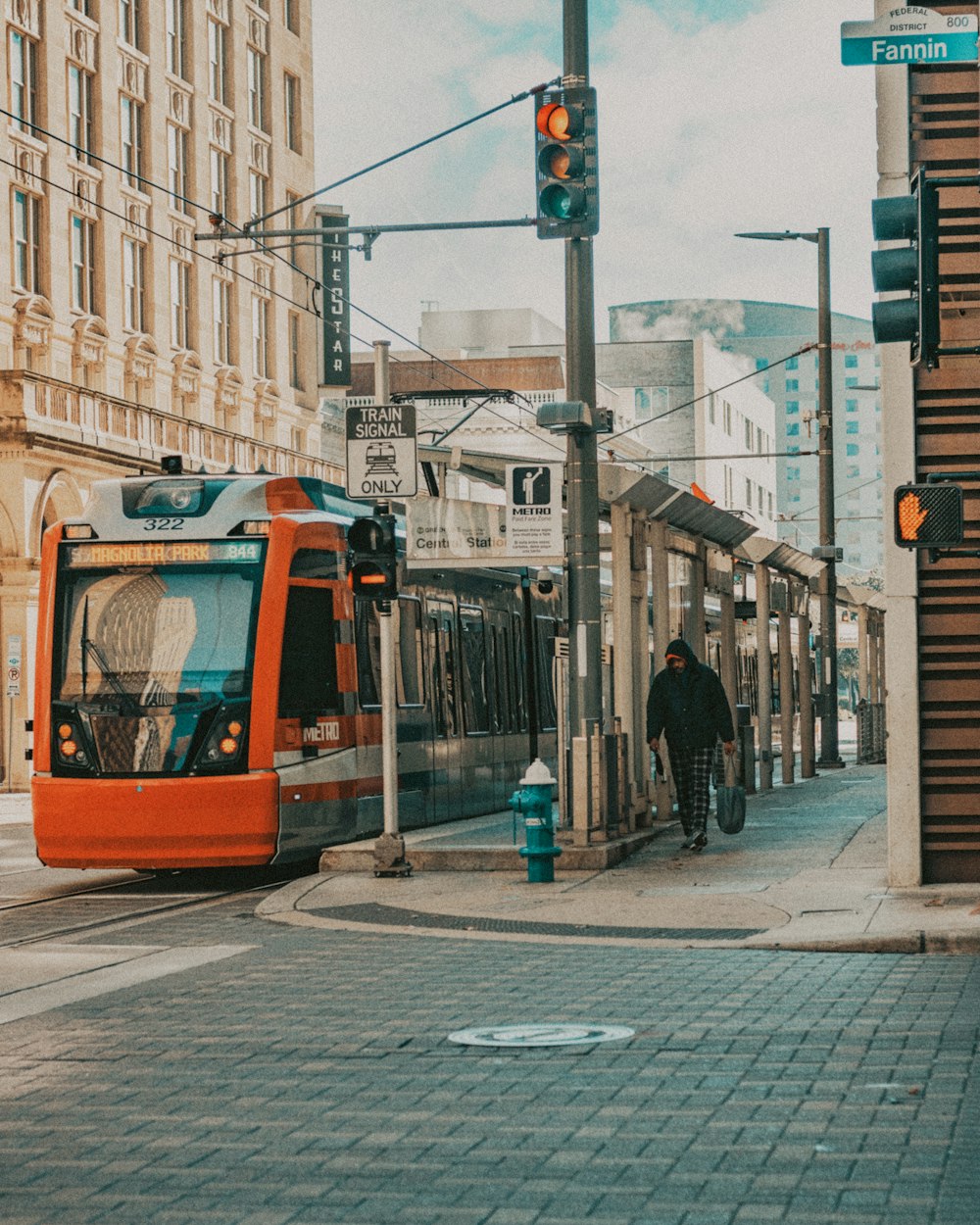 orange tram on the street during daytime