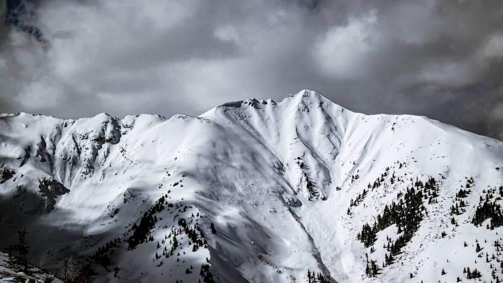 snow covered mountain under cloudy sky during daytime