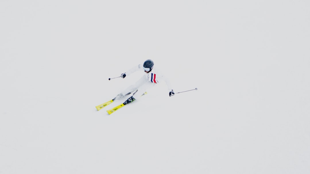 person in white and red suit riding yellow and white snowboard