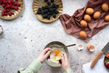person holding stainless steel spoon with sliced orange fruit