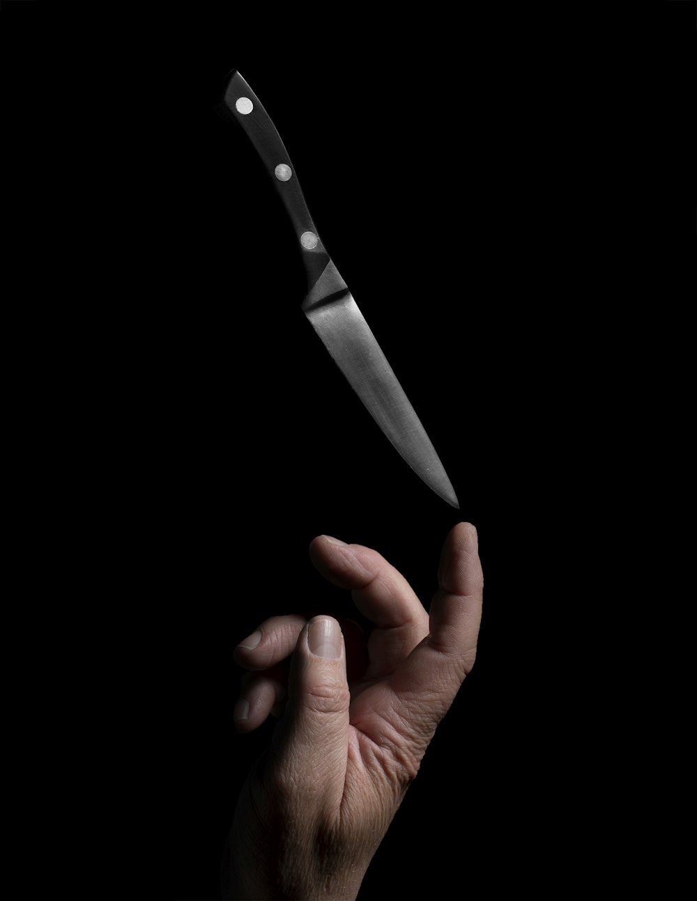 person holding stainless steel bread knife