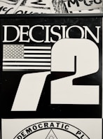 A black and white graphic featuring the word 'DECISION' in large capital letters next to the number '72'. An illustration of the American flag is present beside the word 'DECISION'. The bottom part includes a circular emblem with the words 'DEMOCRATIC PLATFORM' around it.