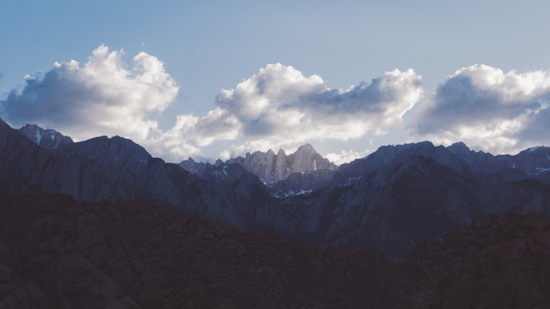 green mountains under white clouds and blue sky during daytime