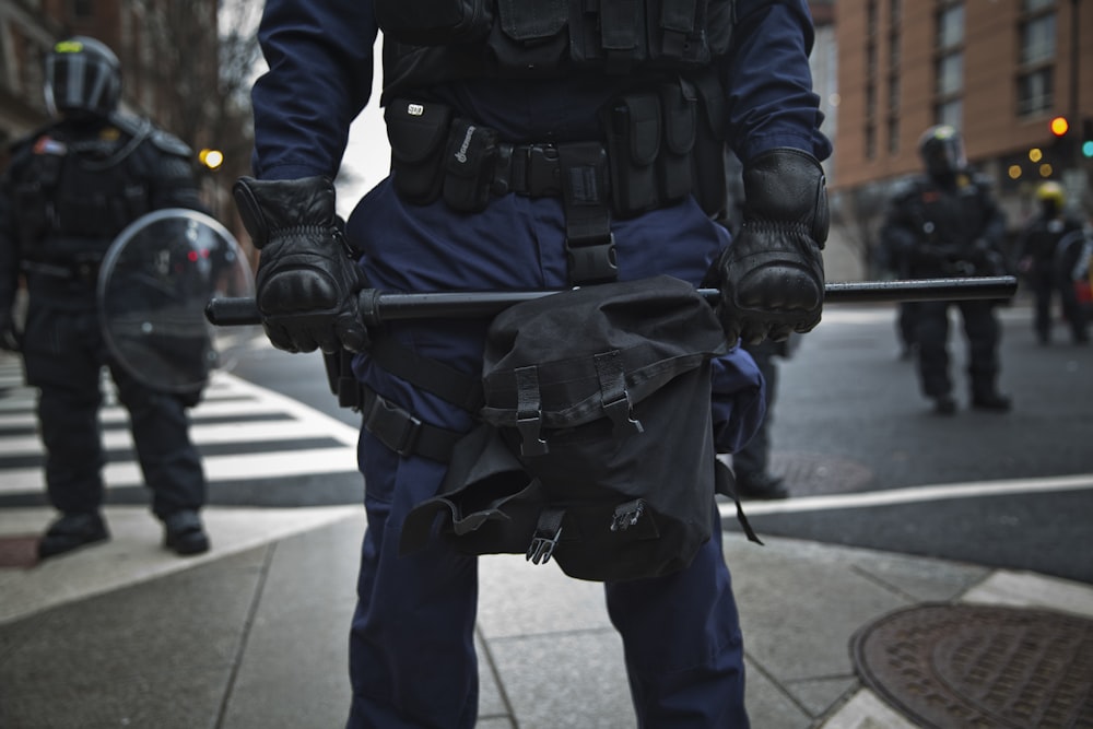 man in black leather jacket holding rifle