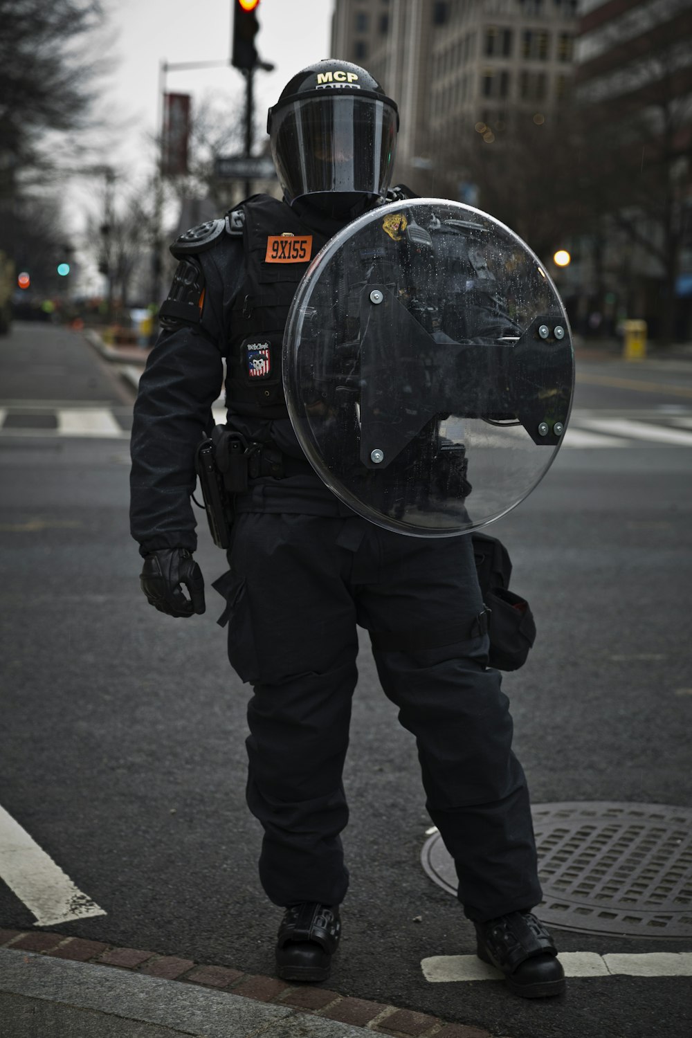 uomo in giacca e pantaloni neri in piedi sulla strada durante il giorno