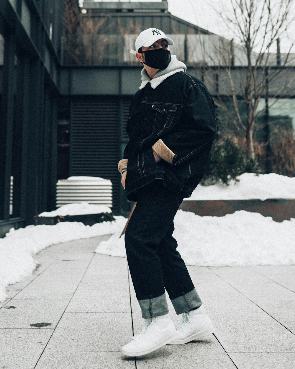 man in black coat and black pants standing on snow covered ground during daytime