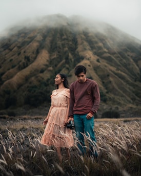 man and woman standing on brown grass field during daytime