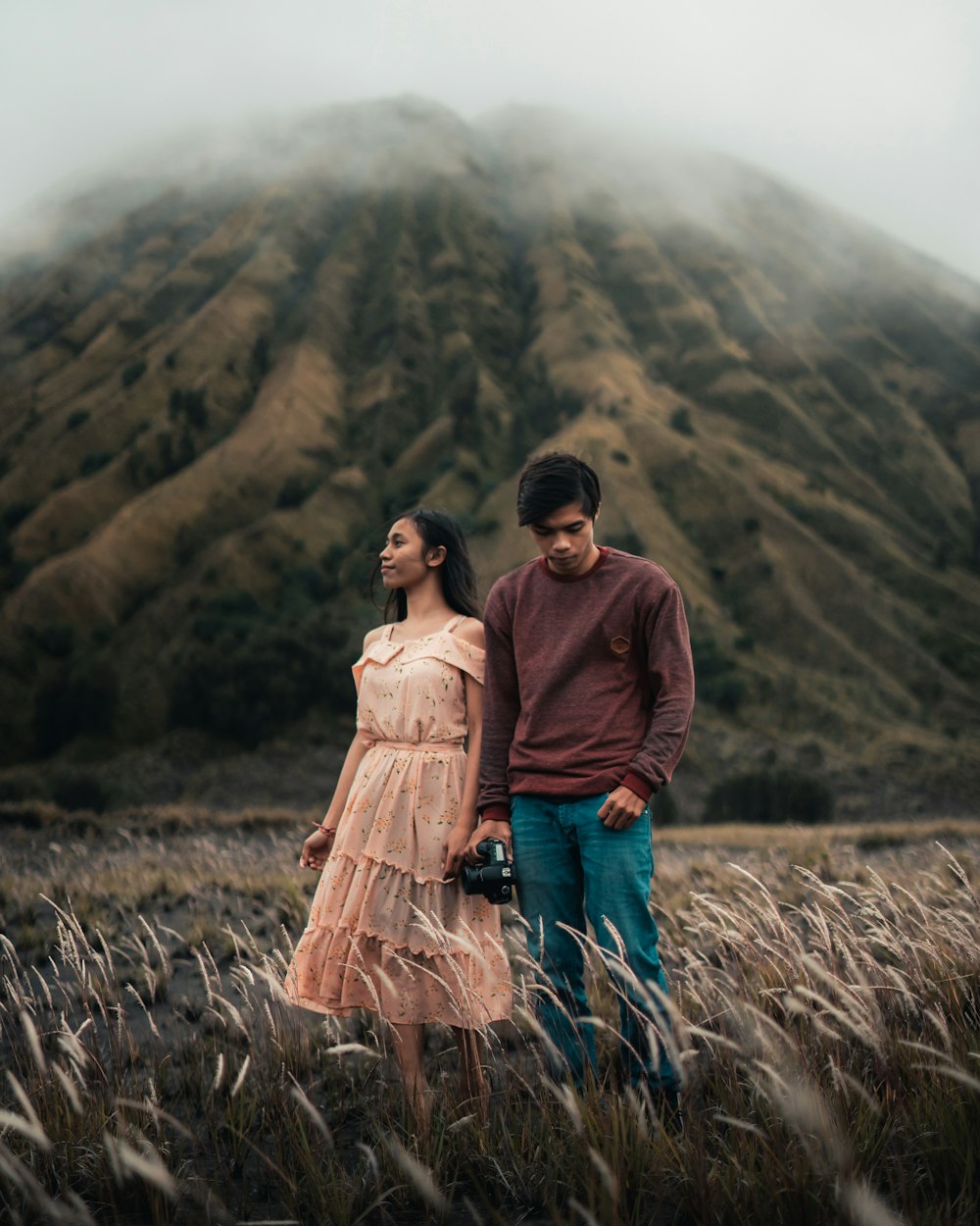 man and woman standing on brown grass field during daytime