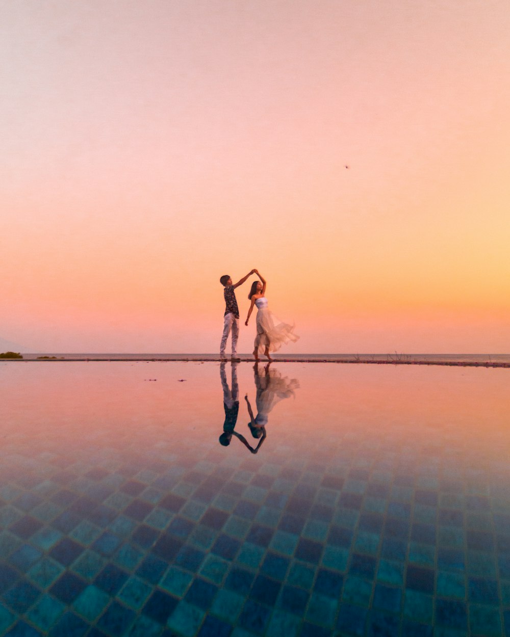 2 women standing on blue and white concrete floor during daytime