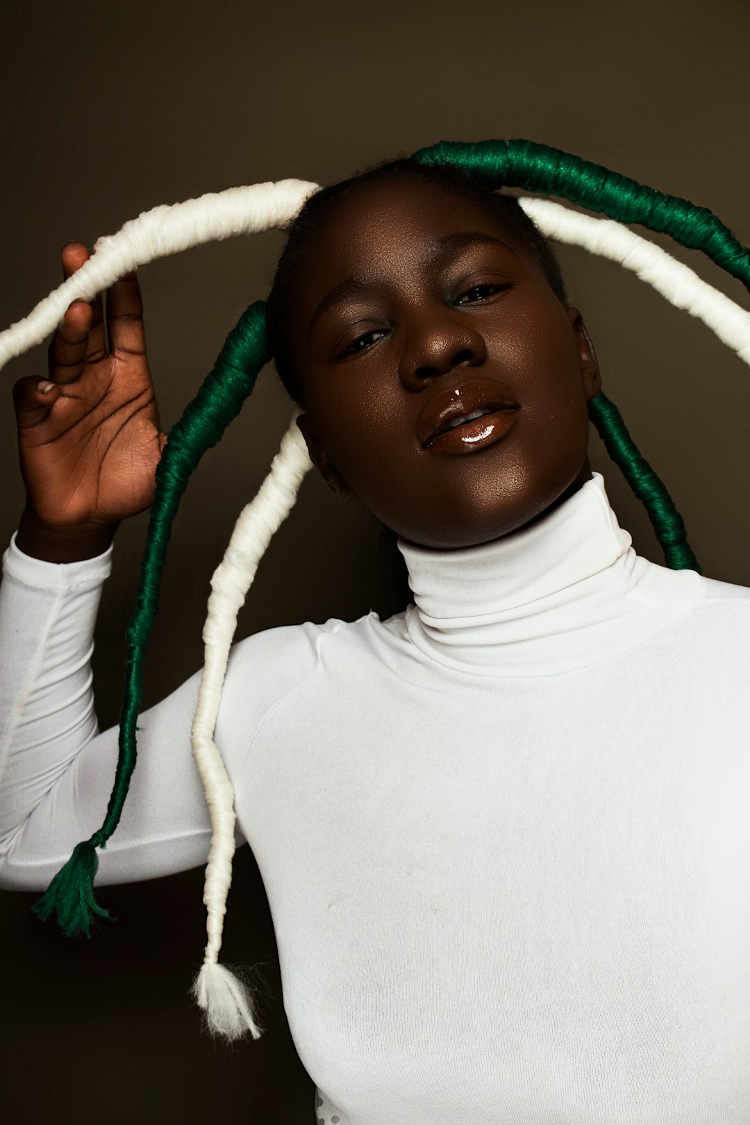 woman in white turtleneck shirt holding blue rope